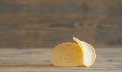 Golden natural potato chips on an old wooden table