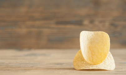 Golden natural potato chips on an old wooden table