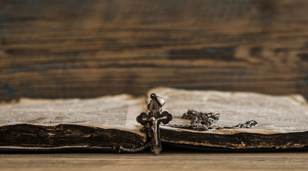 Religion. A cross with a chain against a old book