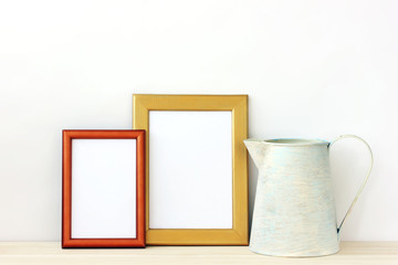 Empty gold photo frames and pitcher.