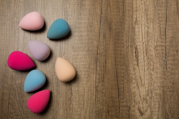 Set of beauty blenders on a wood background. Space for text