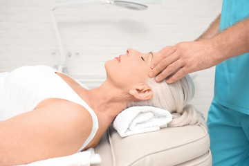 Elderly woman getting head massage at physical therapy office