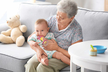 Senior woman playing with her little grandchild at home