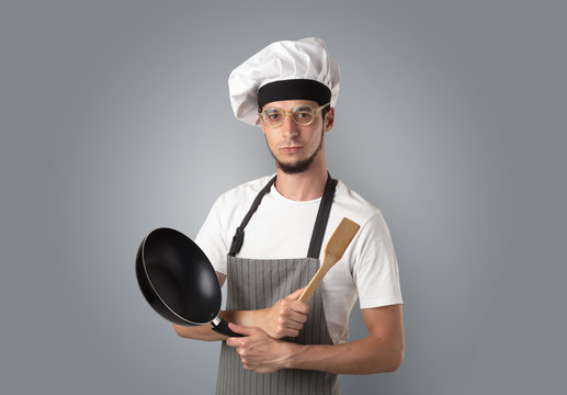 Cook with kitchen tools and empty wallpaper