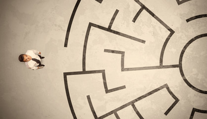 Lost business man looking for a way in circular labyrinth