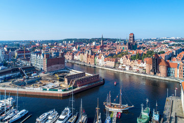 Gdansk, Poland. Old city with the oldest medieval port crane (Zuraw) in Europe, St Mary church, Town hall tower, Motlawa River, World War II ruins, building site, yachts . Aerial view, sunrise light. © nahlik