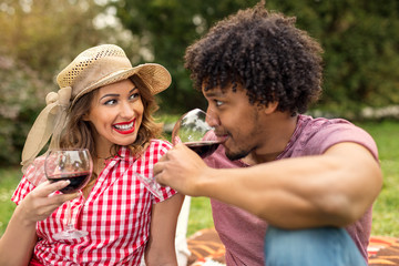 Happy young couple drinking wine on a picnic