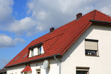 Dach budynku jednorodzinnego z czerwonej dachówki. - obrazy, fototapety, plakaty