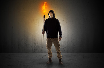 Man walking in an empty space with burning flambeau