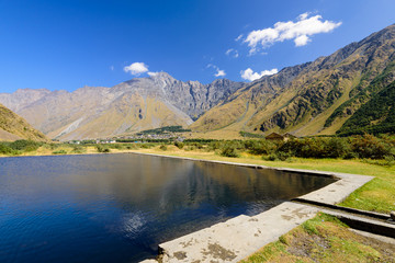 Mineral water pool on the background of picturesque mountains is a popular natural attraction near Stepantsminda (Kazbegi) village, Caucasus, Georgia
