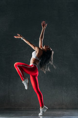 Young beautiful female dancer is posing in the studio