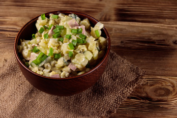 Traditional Russian festive salad Olivier on wooden table