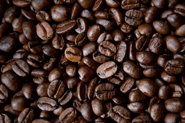 Dark brown roasted coffee beans closeup background