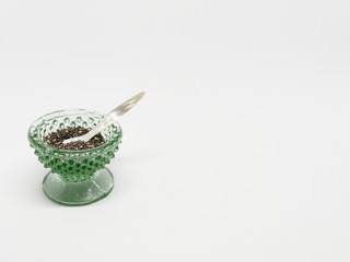 Quinoa in grünem Glasgefäß auf weißem Hintergrund, mit Copy space