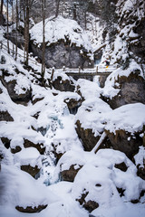 Young women hiking through snowy gorge Baerenschuetzklamm with frozen waterfalls