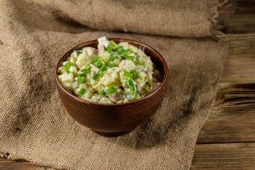 Traditional Russian festive salad Olivier on wooden table