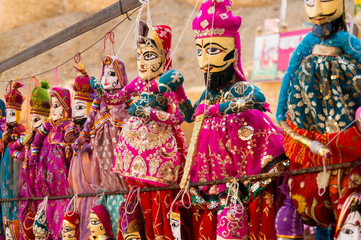 Obraz premium Traditional rajasthani puppets showing a couple with a bearded man and beautiful woman in traditional rajasthani apparel. These are famous tourist souveniers for travellers to Rajasthan
