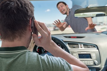 Driver calling using smartphone in car is going to hit pedestrian. © vchalup