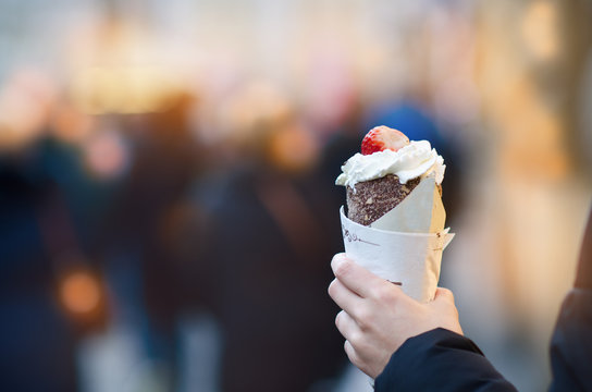 Trdelnik or trdlo is traditional Czech sweet. Woman hand keep trdlo in Prague street. Street food.