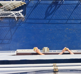 Men's hands holding glasses of wine on a ship deck