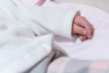 Braccio e mano rilassati di neonato nella culla