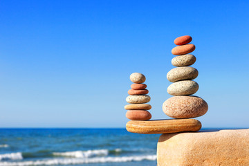 Fototapeta na wymiar Stones balance on a background of blue sky and sea