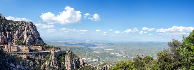 MONTSERRAT, SPAIN. Panoramic view of the Abbey of Santa Maria de Montserrat in the Montserrat mountains - obrazy, fototapety, plakaty