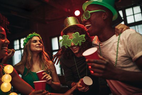 Multi-ethnic friends celebrating St. Patrick's Day in nightclub