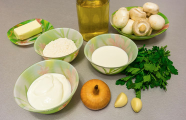 Ingredients for cooking stroganoff gravy: mushrooms, onion, garlic, butter, sour cream, heavy cream, broth, flour, fresh herbs, salt, ground pepper