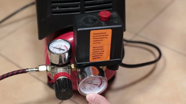 Bleeding of air from the receiver of the compressor, close up view at hand and manometer