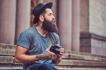 A handsome hipster male with a stylish beard and tattoo on his a