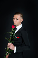 Man with red rose on dark background