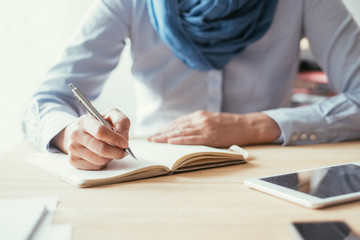 Closeup of Lady Writing in Notebook in Office