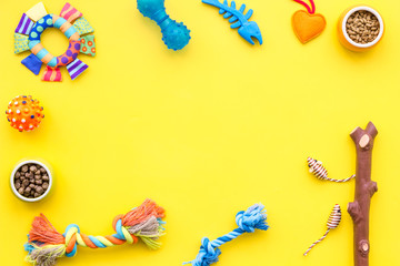 grooming equipment with brushes and toys for care and training pet yellow background top view mock up