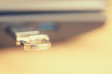 A metal flash drive in the usb slot of a laptop close-up.