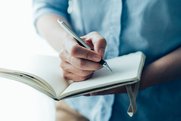 Closeup of Woman Writing in Notebook
