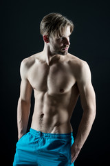 Fototapeta na wymiar Man athlete show muscular torso in blue shorts