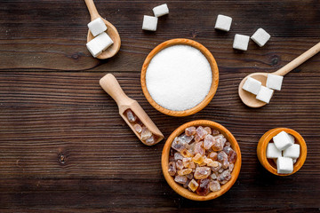 Sugar types. Cane, refind, granulated, cubes, candy sugar. Dark wooden background top view copy space