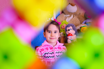 cute girl on the background of her toys smiling