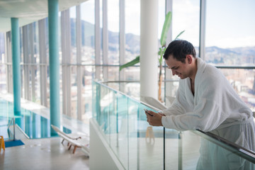 Happy guy communicating on telephone in luxury spa hotel