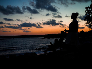 Obraz premium Silhouettes on the beach and the setting sun