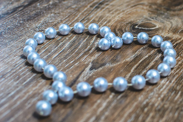 heart made of beads on a wooden background