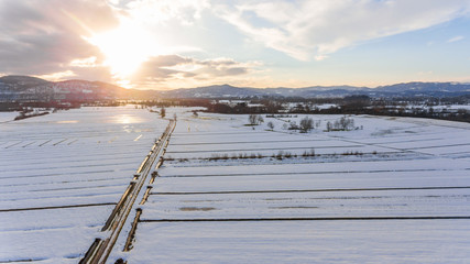 Snow covered countryside at sunset.