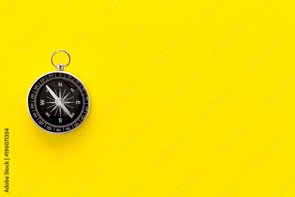 Wall mural compass on yellow background top view copy space