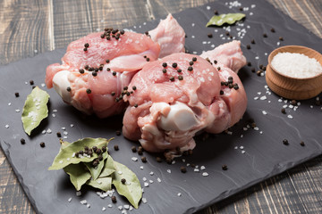 two turkey's shoulders, the upper part of the wing, raw meat, on black slate