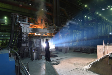 Schmelzofen in einer Giesserei - Arbeiter am Hochofen // Melting furnace in a foundry - Workers at...