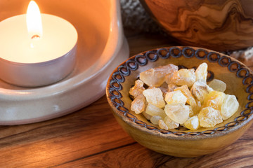 Frankincense resin iin a wooden bowl with a candle