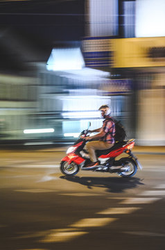 Motion Blur. Scooter on Night City Road. Abstrsct Blur Background of Night Cityspace