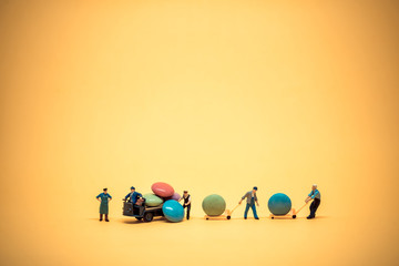 Miniature workers unloading sugar coated chocolate candies from truck