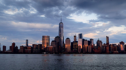 Fototapeta na wymiar Panoramic view of Manhattan skyline with its reflection in Hudson river at dusk from New Jersey pier. New York, USA